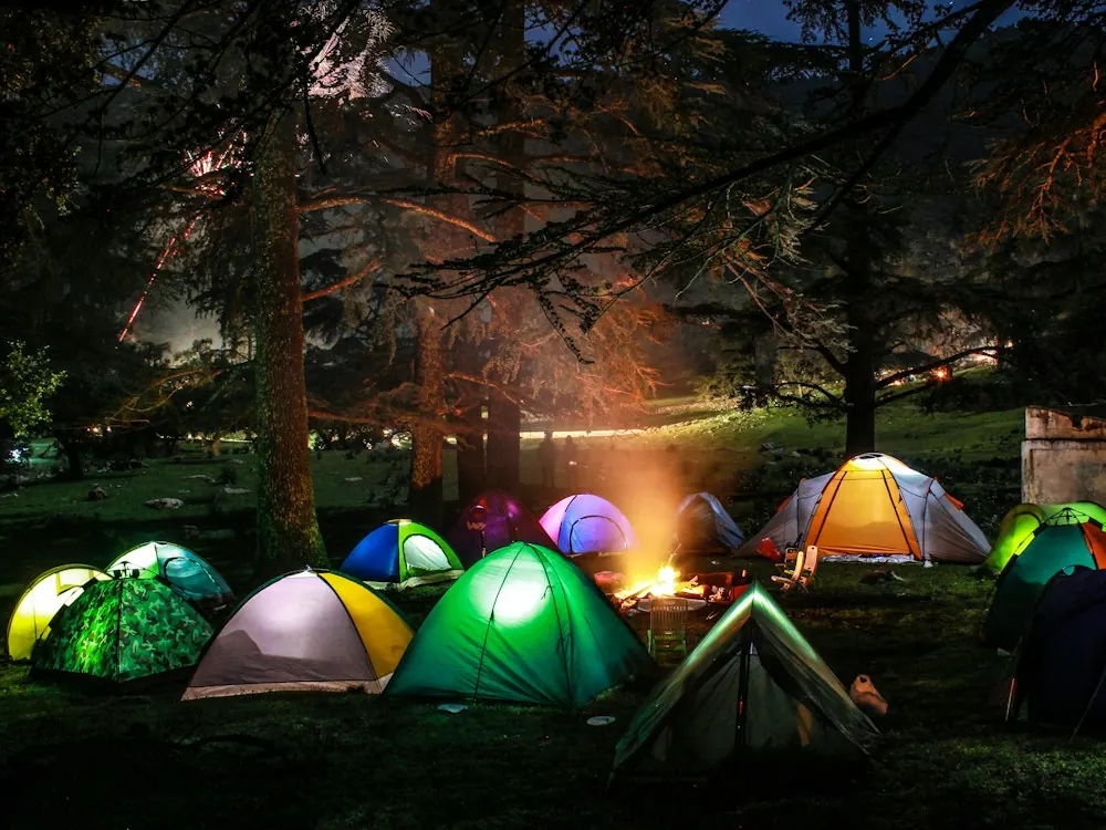 A camp at night, tents lit around a fire